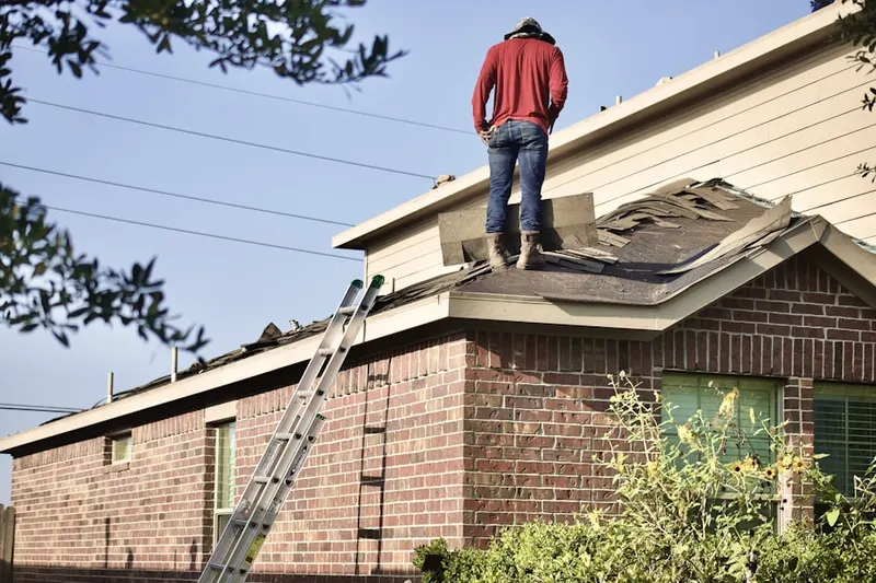Professional roofer working on a residential roof in Mantua